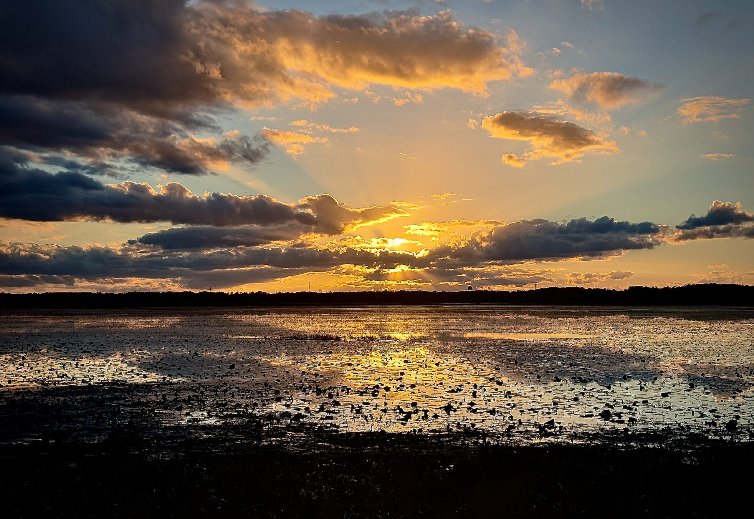 Golden sunset reflection photography over water and clouds